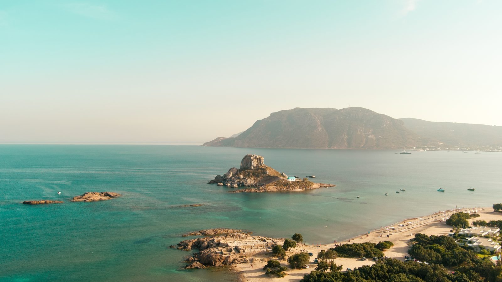 Kastri islet and the turquoise shallows of Agios Stefanos beach at Kefalos, Kos, from above