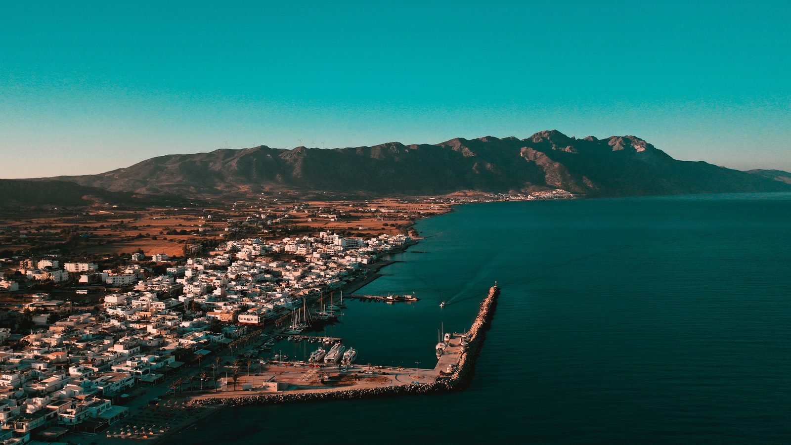 Kardamena from the air, with the long sandy beach and the harbour jetty