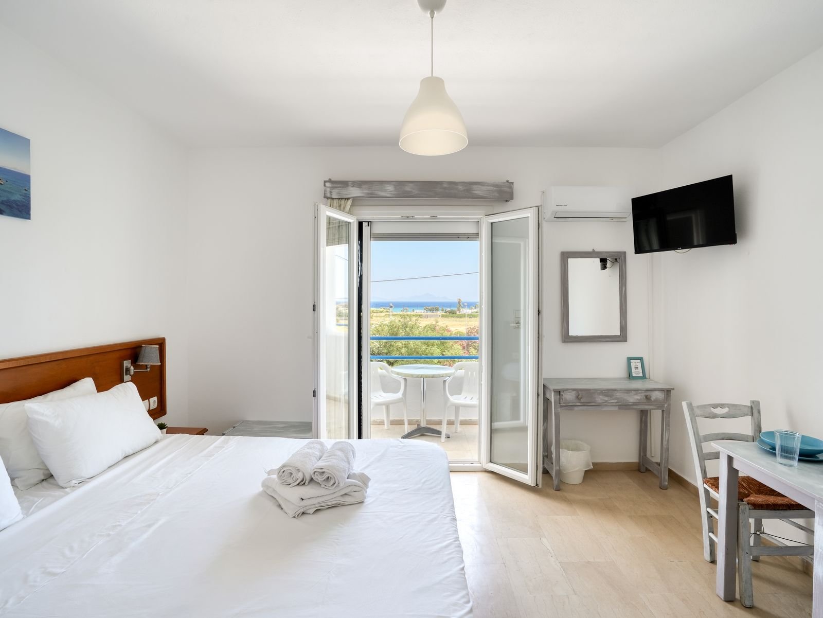 Sea view studio with the balcony door open to the Aegean