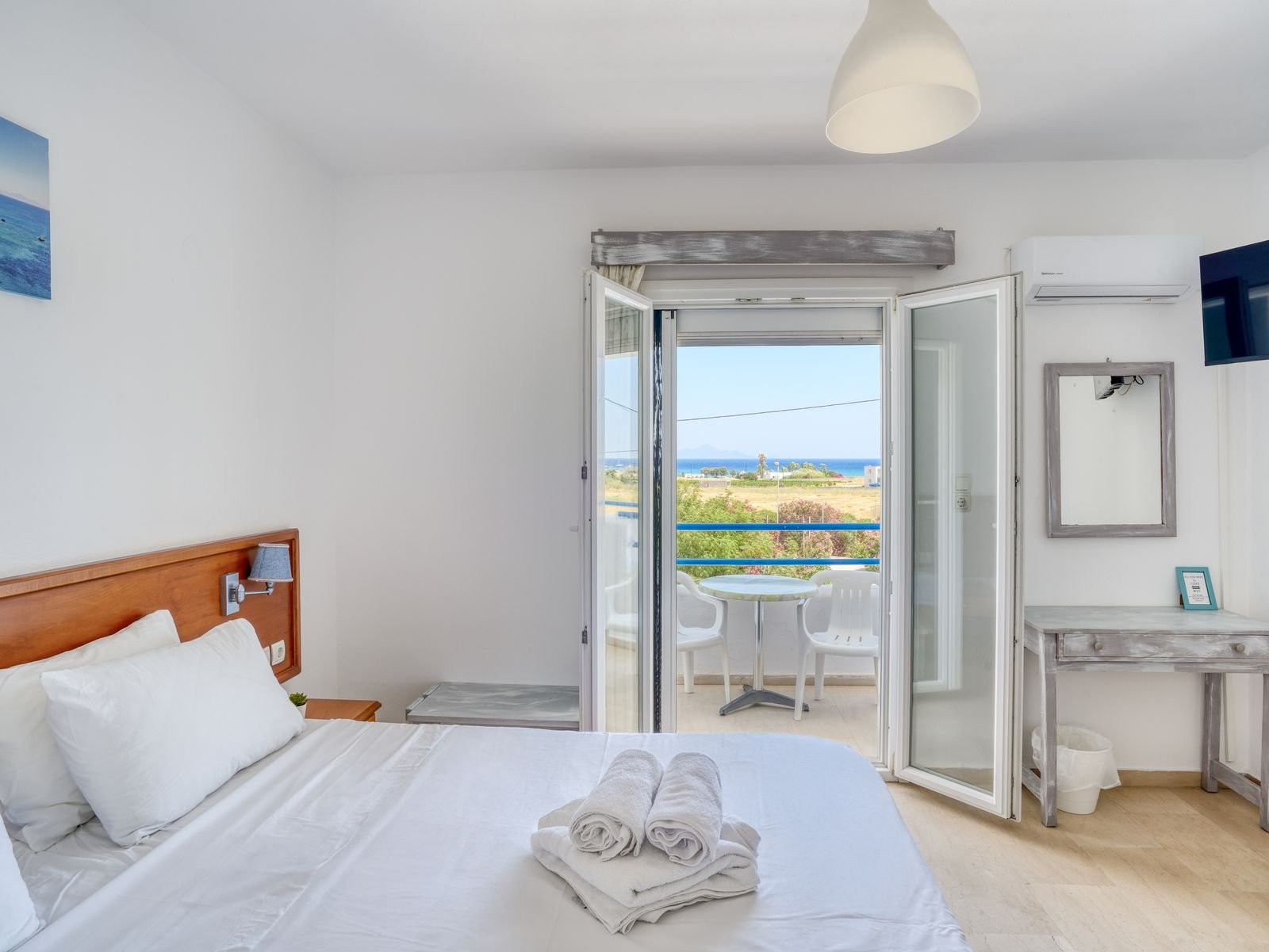 Double bed with fresh towels and sea view balcony